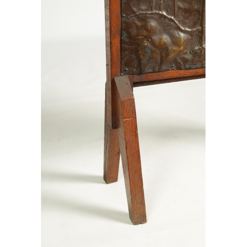 555 - AN ARTS AND CRAFTS PRESSED BRASS AND OAK FIRE SCREEN with pierced love heart decoration and angled f... 