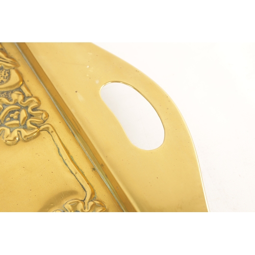 558 - AN STYLISH ARTS AND CRAFTS BRASS RECTANGULAR TRAY with shaped handles to the side and embossed flowe... 