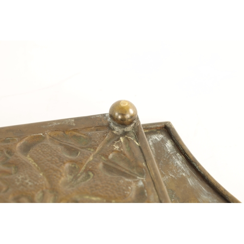 558 - AN STYLISH ARTS AND CRAFTS BRASS RECTANGULAR TRAY with shaped handles to the side and embossed flowe... 