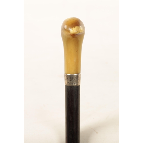 560 - A LATE 19TH CENTURY EBONY AND HORN WALKING CANE with silvered collar and tapering shaft. (91cm overa... 