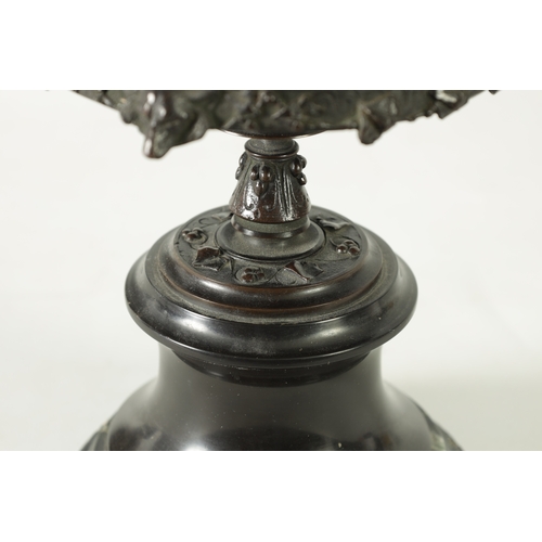593 - A 19TH CENTURY BRONZE LIDDED TAZZA with figural finial and stylised floral decoration, raised on a g... 