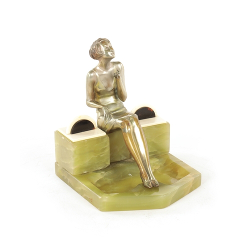 595 - ATT. JOSEF LORENZL. AN ART DECO SILVERED BRONZE FIGURAL INKSTAND modelled as a smoking girl seated o... 