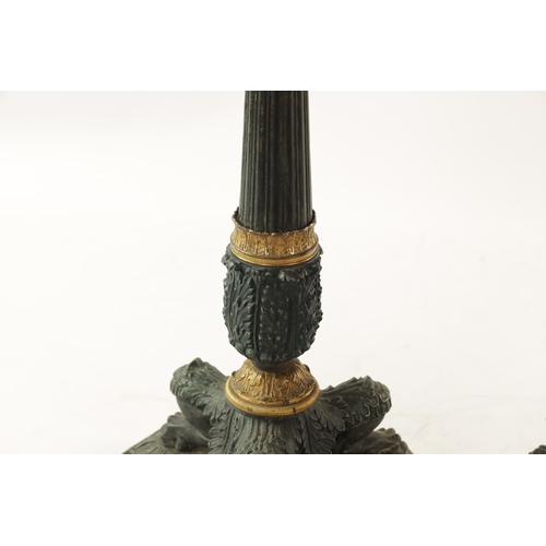 596 - A PAIR OF REGENCY-PATINATED METAL AND BRASS ORMOLU CANDLESTICKS with tapering reeded stems, leaf cas... 