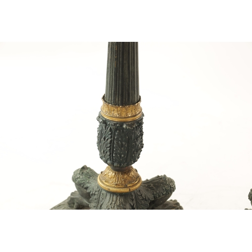 596 - A PAIR OF REGENCY-PATINATED METAL AND BRASS ORMOLU CANDLESTICKS with tapering reeded stems, leaf cas... 