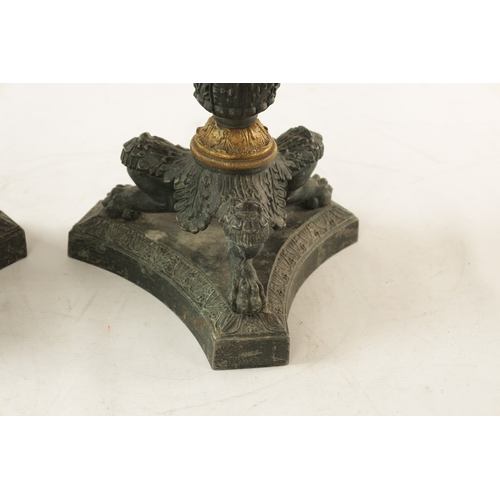 596 - A PAIR OF REGENCY-PATINATED METAL AND BRASS ORMOLU CANDLESTICKS with tapering reeded stems, leaf cas... 