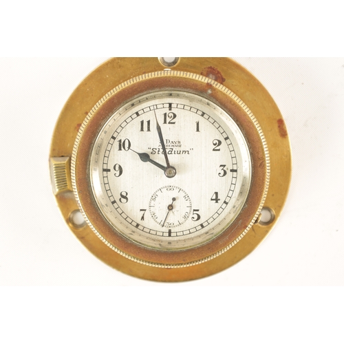 23 - AN EARLY 20TH CENTURY STADIUM 8-DAY BRASS CASED CAR CLOCK with rotating winding bezel, silvered dial... 