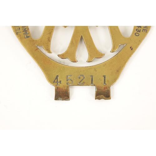 64 - AN EARLY AA BRASS CAR BADGE with winged crest. (12.5cm high)