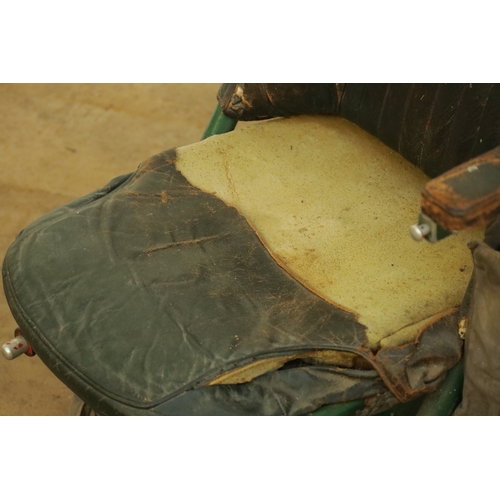 85 - AN EARLY AIRCRAFT LEATHER UPHOLSTERED PILOTS SEAT with adjustable armrests and green steel frame. (1... 