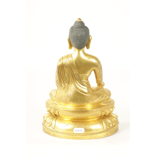 105 - AN EARLY CAST GILT BRONZE TIBETAN BUDDHA seated on a shaped leaf work base. (29cm high )