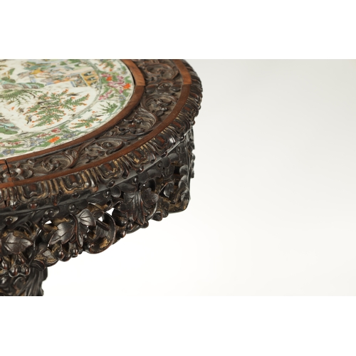 112 - A FINE 19TH CENTURY CHINESE PROFUSELY CARVED CENTRE TABLE WITH CANTONESE PORCELAIN INSET TOP the int... 