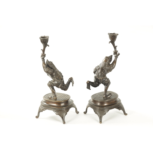 114 - A PAIR OF JAPANESE MEIJI PERIOD PATINATED BRONZE FIGURAL CANDLESTICKS each modelled as a frog warrio... 