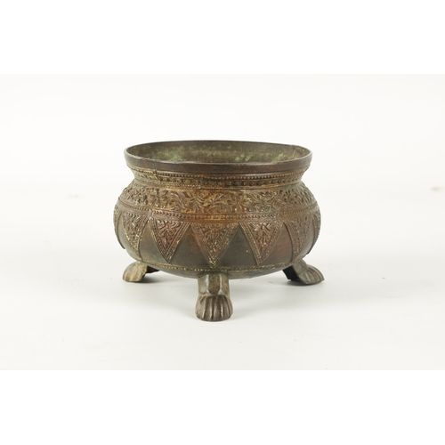 131 - AN EARLY EASTERN BRONZE FOOTED BOWL with floral design edge; raised on paw feet (9.5cm high 14cm dia... 