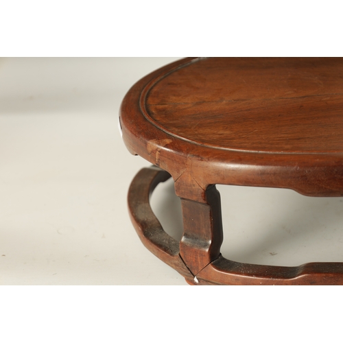 134 - A 19TH CENTURY CHINESE HARDWOOD OVAL SHAPED JARDINIERE STAND with shaped leg supports joined by a su... 