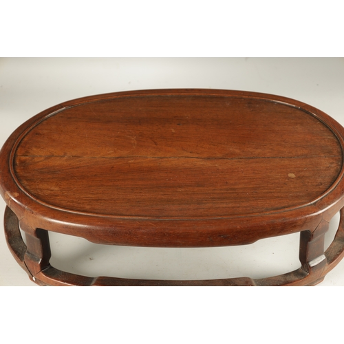 134 - A 19TH CENTURY CHINESE HARDWOOD OVAL SHAPED JARDINIERE STAND with shaped leg supports joined by a su... 