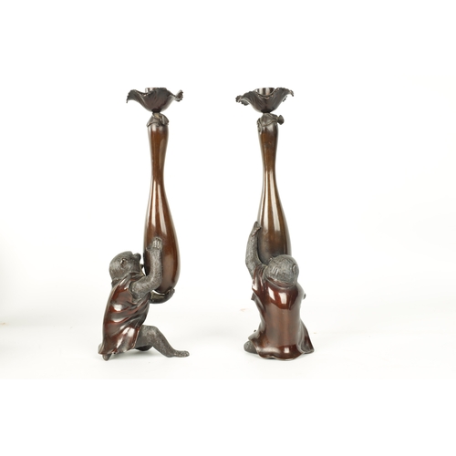 139 - A FINE PAIR OF JAPANESE MEIJI PATINATED BRONZE FIGURAL CANDLESTICKS the plain slender ovoid vase sha... 