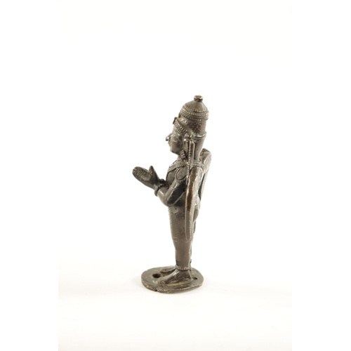 142 - AN EARLY INDIAN CAST BRONZE FIGURE OF A HINDU DEITY with hands closed and standing on a circular bas... 