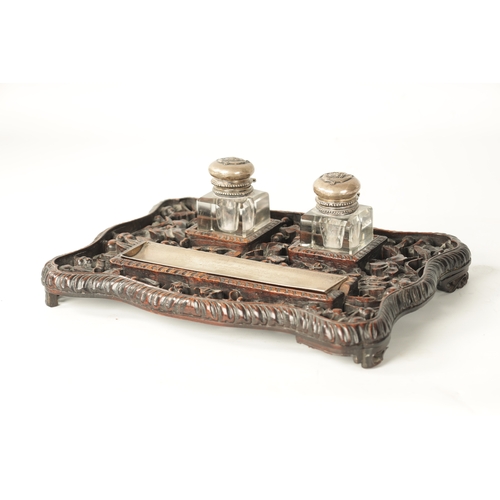 152 - A 19TH CENTURY CHINESE CARVED HARDWOOD AND SILVER MOUNTED DESK SET with dished silver pen tray and c... 