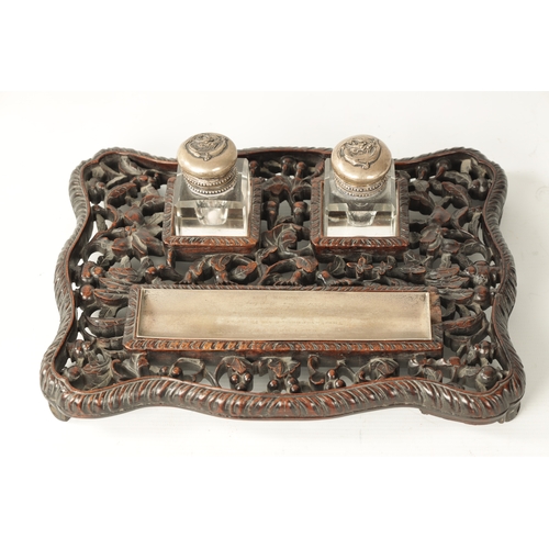 152 - A 19TH CENTURY CHINESE CARVED HARDWOOD AND SILVER MOUNTED DESK SET with dished silver pen tray and c... 