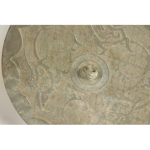 177 - AN EARLY WARRING STATES TYPE CIRCULAR BRONZE MIRROR with embossed starburst centre. (26cm diameter)