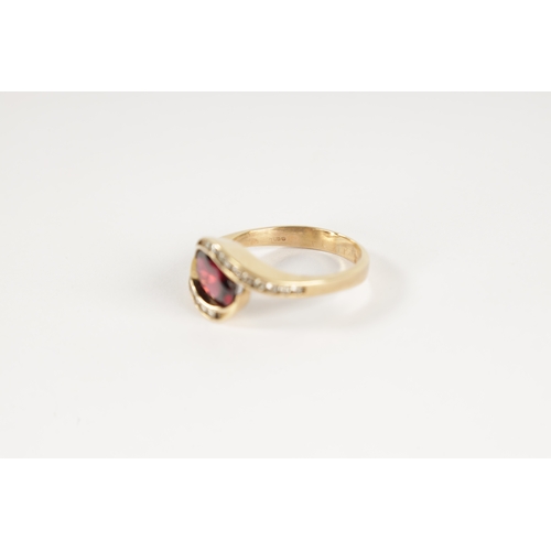 196 - A .375 HALLMARKED YELLOW GOLD AND GARNET SET DRESS RING the oval set stone in a swirled setting with... 