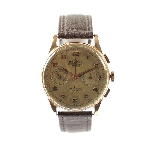 270 - AN 18CT YELLOW GOLD HEDICOR 19 JEWEL MANUAL WIND CHRONOGRAPH MANUAL GENTLEMANS WRISTWATCH on a brown... 