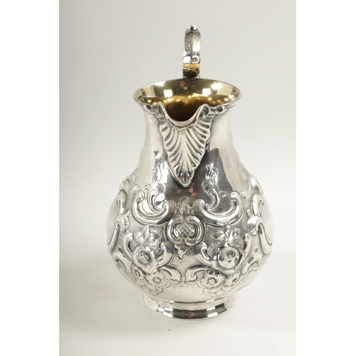 281 - A MID 19TH CENTURY SILVER AND SILVER GILT ALE JUG of bulbous form with embossed rococo style swagwor... 