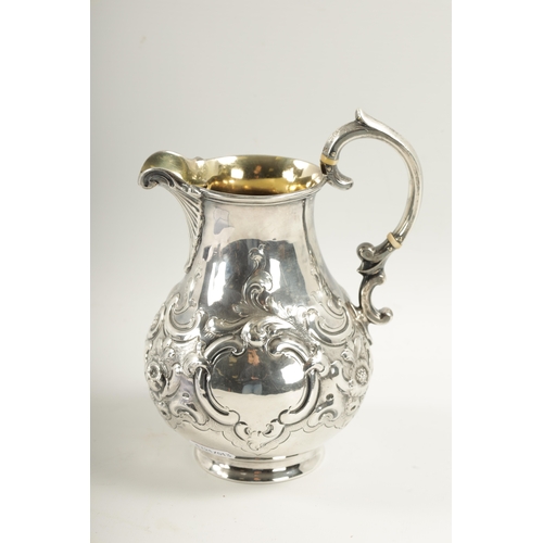 281 - A MID 19TH CENTURY SILVER AND SILVER GILT ALE JUG of bulbous form with embossed rococo style swagwor... 