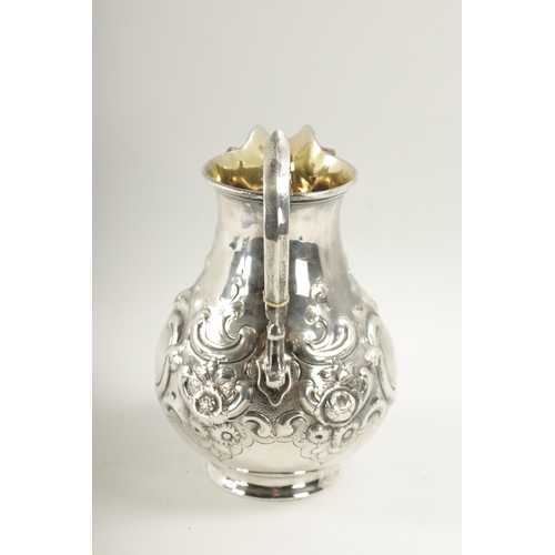 281 - A MID 19TH CENTURY SILVER AND SILVER GILT ALE JUG of bulbous form with embossed rococo style swagwor... 