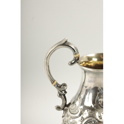 281 - A MID 19TH CENTURY SILVER AND SILVER GILT ALE JUG of bulbous form with embossed rococo style swagwor... 