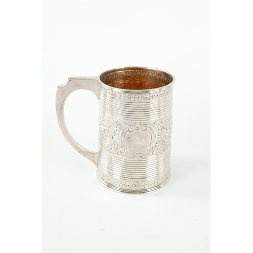 289 - A GEORGE III SILVER MUG of ribbed tapering form with gilt interior with crested later embossed centr... 