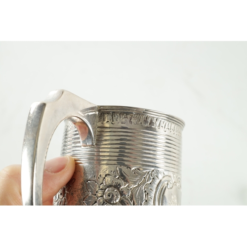 289 - A GEORGE III SILVER MUG of ribbed tapering form with gilt interior with crested later embossed centr... 