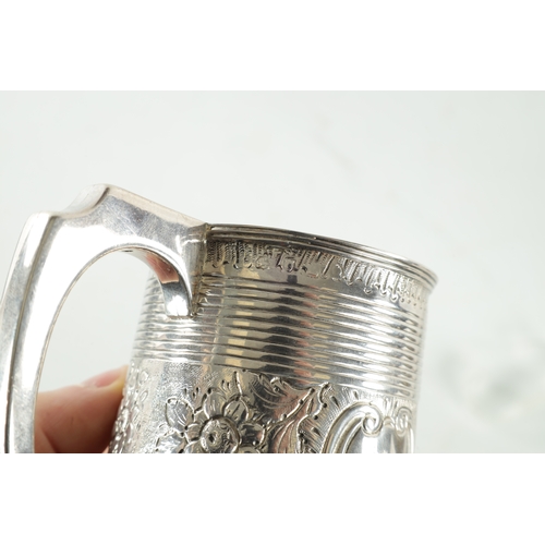 289 - A GEORGE III SILVER MUG of ribbed tapering form with gilt interior with crested later embossed centr... 