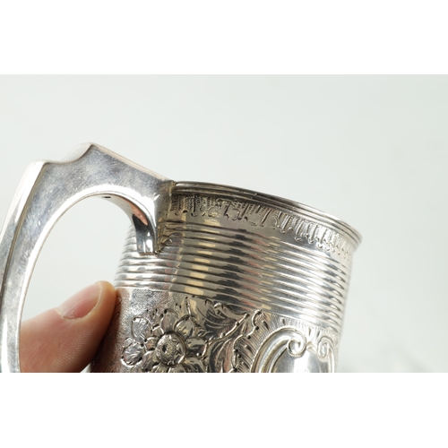 289 - A GEORGE III SILVER MUG of ribbed tapering form with gilt interior with crested later embossed centr... 