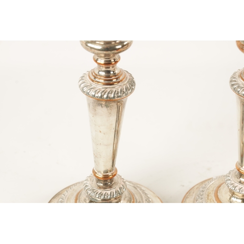 306 - TWO OLD SHEFFIELD SILVER PLATED CANDLESTICKS with tapered stems and circular bases (22cm high)