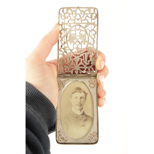 307 - A LATE VICTORIAN SILVER PHOTO FRAME of rectangular form with pierced sprung hinged cover decorated w... 