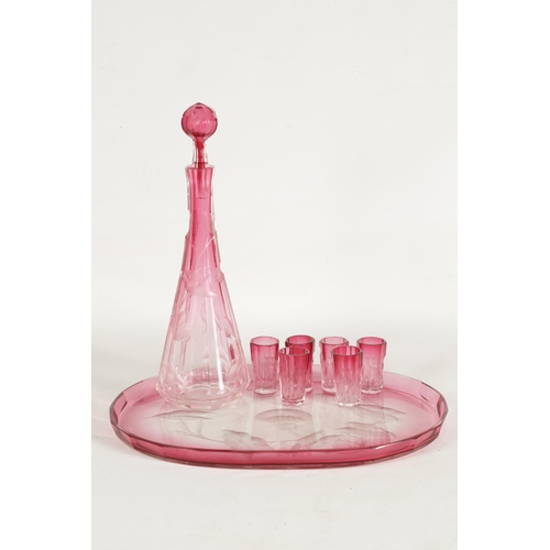 31 - AN ART NOUVEAU RUBY AND CLEAR GLASS MOSER DECANTER, TRAY AND SIX GLASSES deeply cut with intaglio de... 