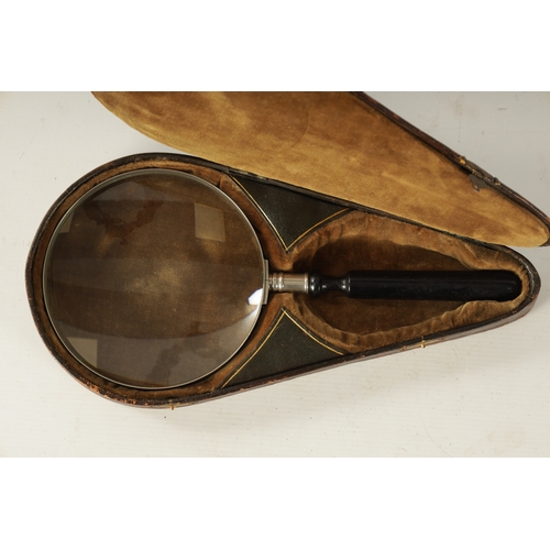 334 - A GOOD 19TH CENTURY CASED LIBRARY MAGNIFYING GLASS with silvered surround and ebonised handle, fitte... 