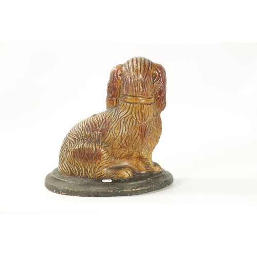 60 - A LARGE 19TH CENTURY SALT GLAZE SCULPTURE OF A SPANIEL seated on a green moulded oval base (35cm hig... 