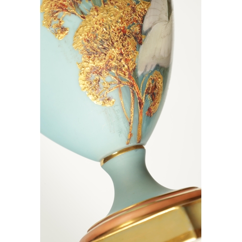 62 - CHARLES H C. BALDWYN A FINE PAIR OF ROYAL WORCESTER RICHLY GILT AND SKY BLUE GROUND OVOID EWERS WITH... 