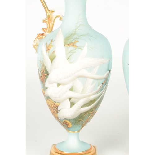 62 - CHARLES H C. BALDWYN A FINE PAIR OF ROYAL WORCESTER RICHLY GILT AND SKY BLUE GROUND OVOID EWERS WITH... 