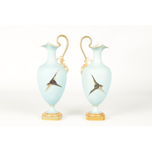 62 - CHARLES H C. BALDWYN A FINE PAIR OF ROYAL WORCESTER RICHLY GILT AND SKY BLUE GROUND OVOID EWERS WITH... 