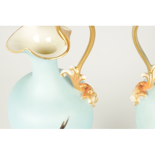 62 - CHARLES H C. BALDWYN A FINE PAIR OF ROYAL WORCESTER RICHLY GILT AND SKY BLUE GROUND OVOID EWERS WITH... 