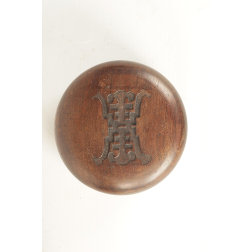 69 - A 19TH CENTURY CHINESE HUANGHUALI INK TABLET in a circular case with rounded top and carved insignia... 