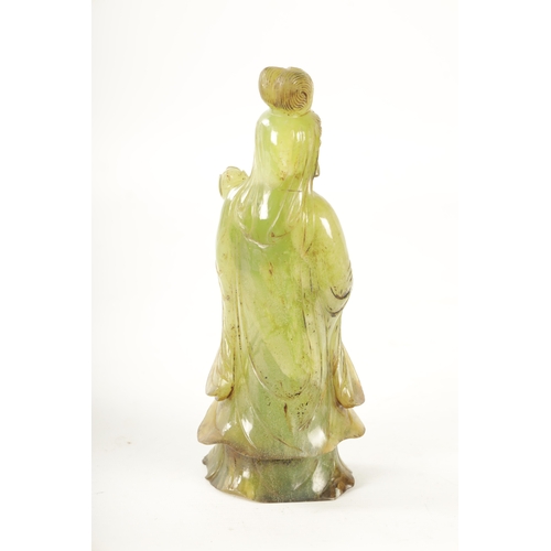 83 - A CHINESE CARVED GREEN JADE GEISHA modelled holding a lotus flower - in a fitted box (24cm high)