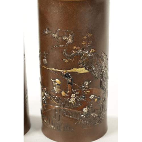 87 - A FINE PAIR OF JAPANESE MEIJI PERIOD BRONZE AND MIXED METAL CYLINDRICAL VASES decorated with figures... 