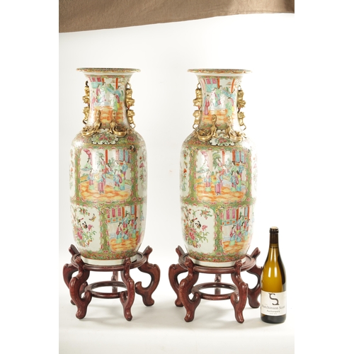 91 - A LARGE PAIR OF 19TH CENTURY CANTON FAMILLE ROSE VASES ON STANDS having panelled figural scenes and ... 