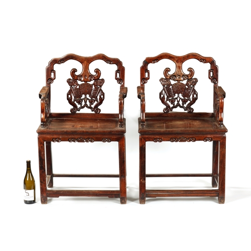 99 - A GOOD PAIR OF 19TH CENTURY CHINESE HARDWOOD OPEN ARMCHAIRS the shaped geometric backs with ornate c... 