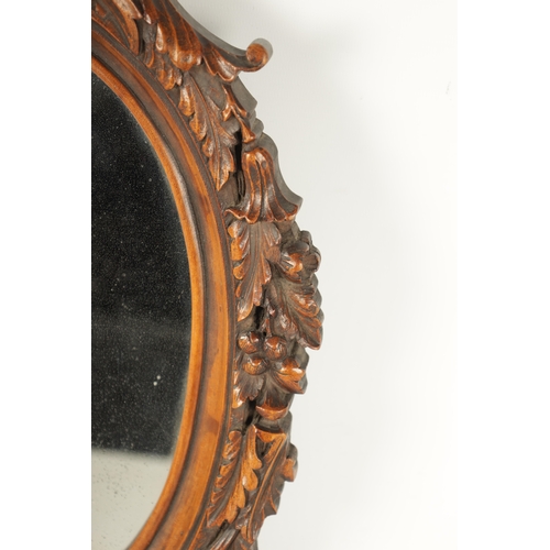 340 - A 19TH CENTURY CARVED WALNUT BLACK FOREST HANGING MIRROR with a monkey head pediment and leaf carved... 