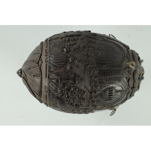 349 - A FINE 18TH CENTURY CARVED COCONUT POWDER FLASK decorated with figures in a banqueting hall, having ... 