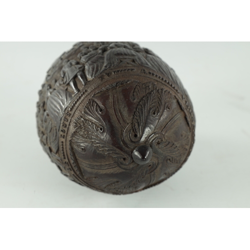 349 - A FINE 18TH CENTURY CARVED COCONUT POWDER FLASK decorated with figures in a banqueting hall, having ... 